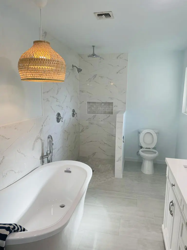 A bathroom with a toilet, sink and shower.