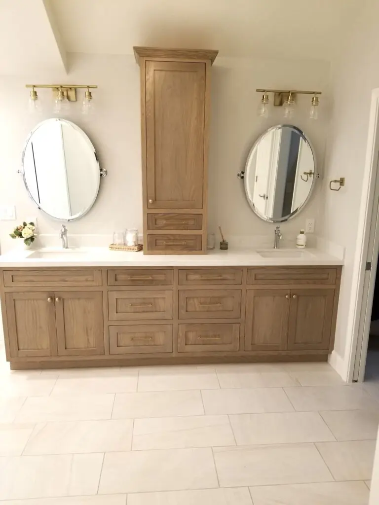 A bathroom with two mirrors and a double sink.