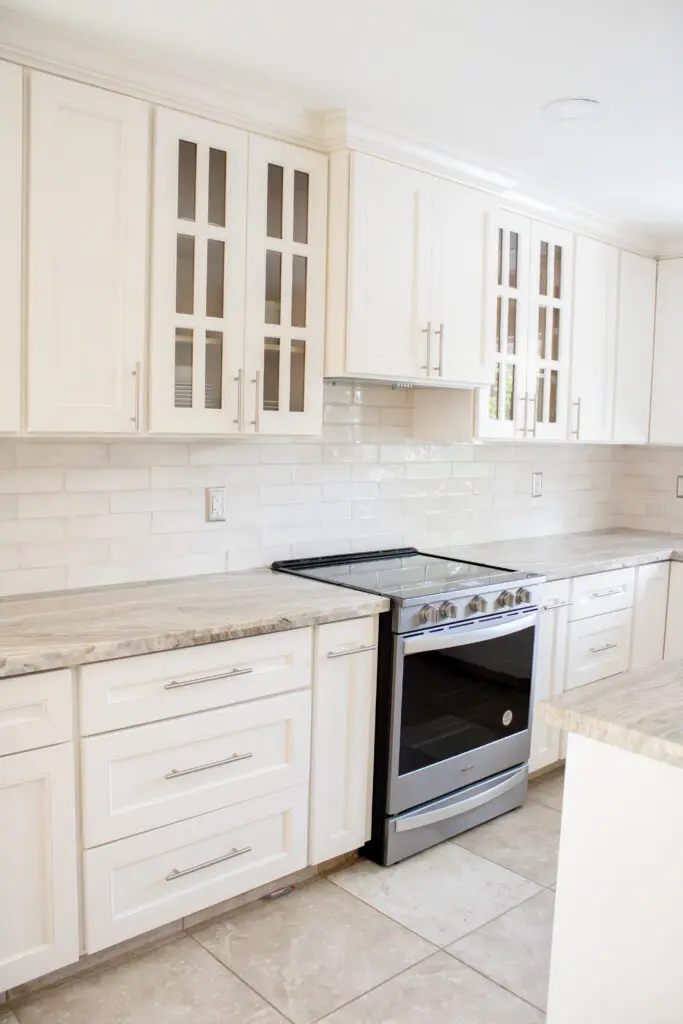 A kitchen with white cabinets and granite countertops.