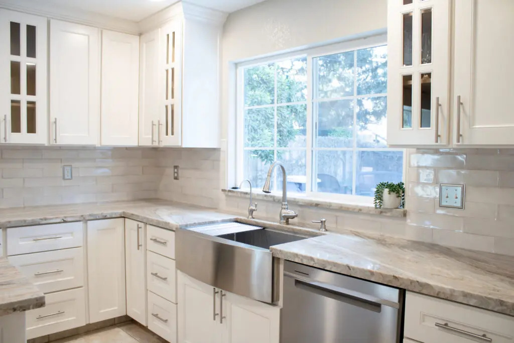 A kitchen with white cabinets and stainless steel appliances.