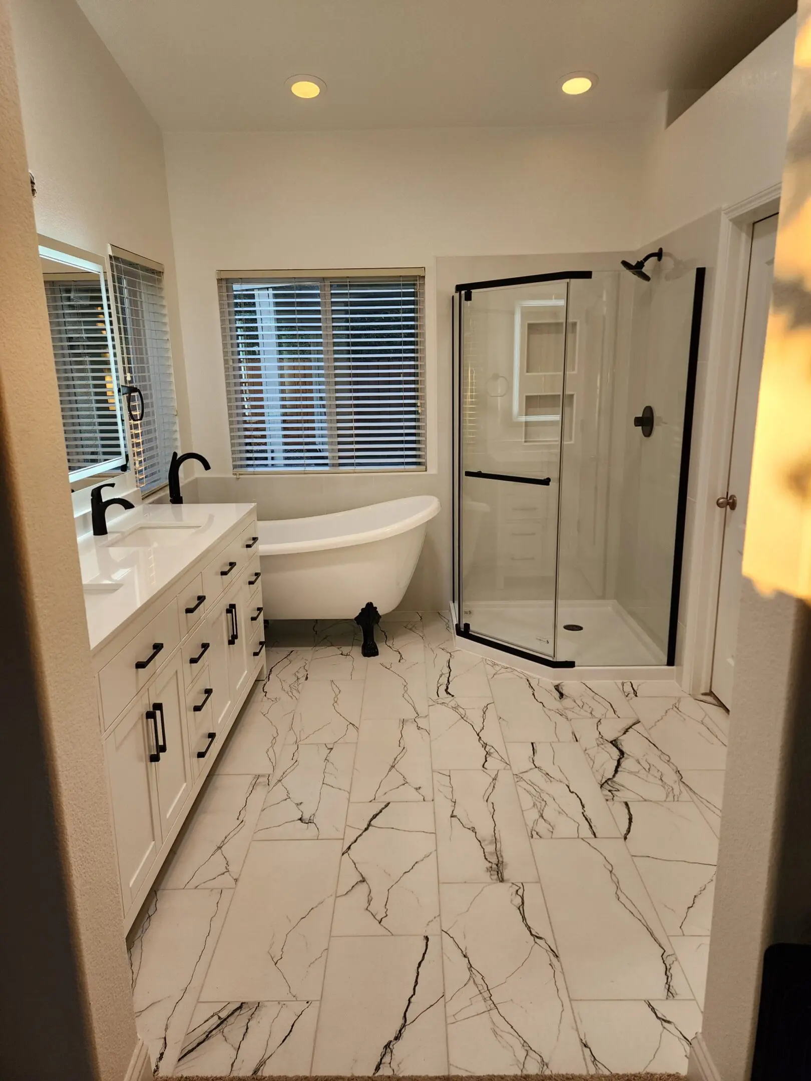 A bathroom with white cabinets and a tub