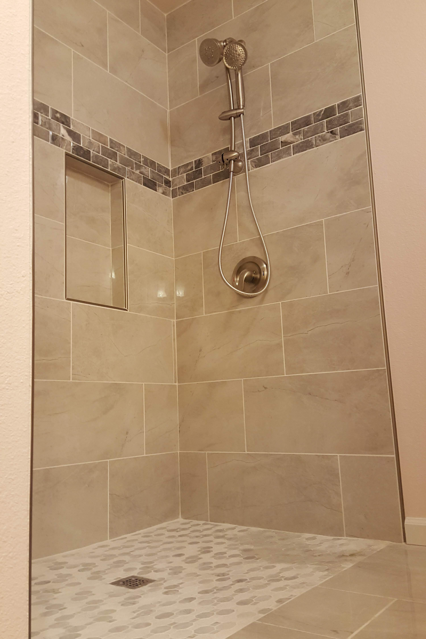 A bathroom with a shower and tiled walls.