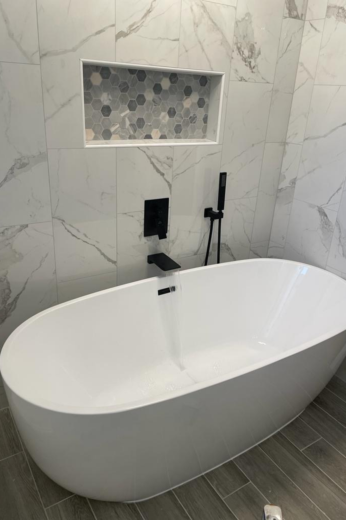 A white bath tub sitting in the middle of a bathroom.