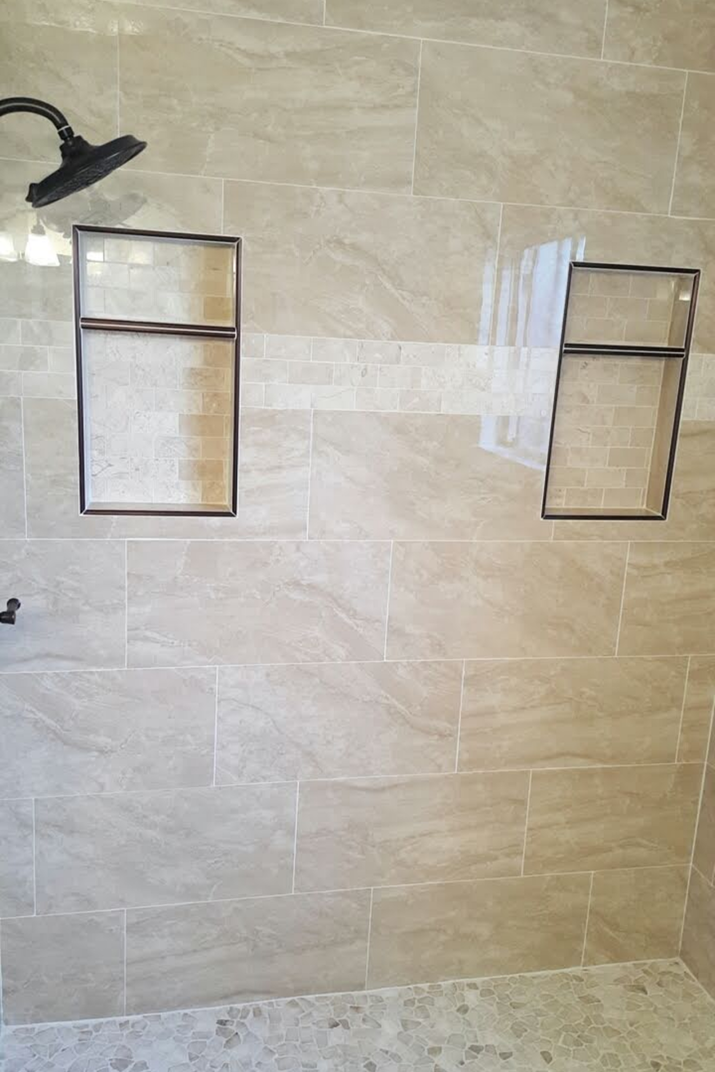 A bathroom with two tiled shelves on the wall.