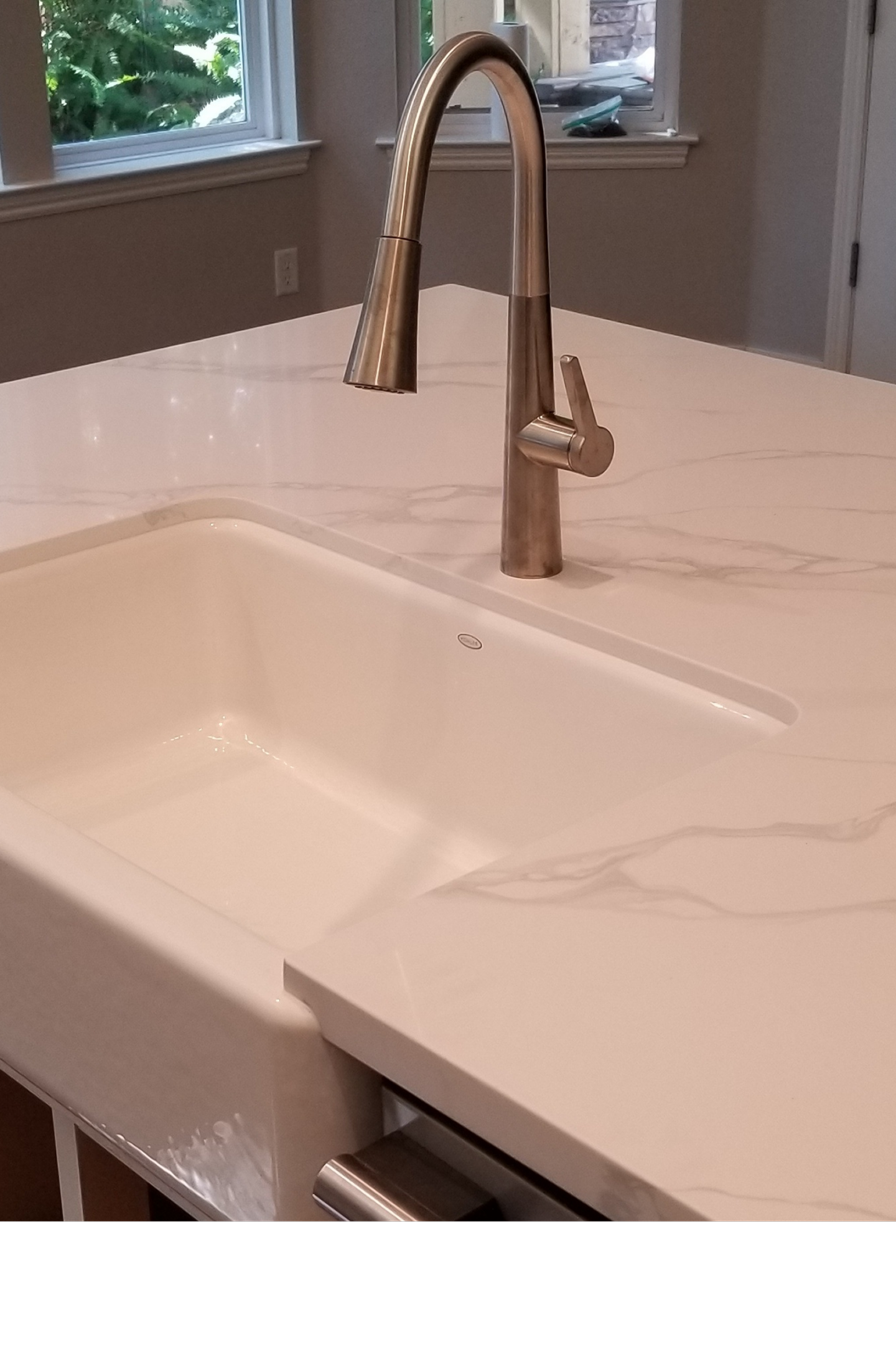 A white sink sitting under a faucet in the middle of a room.