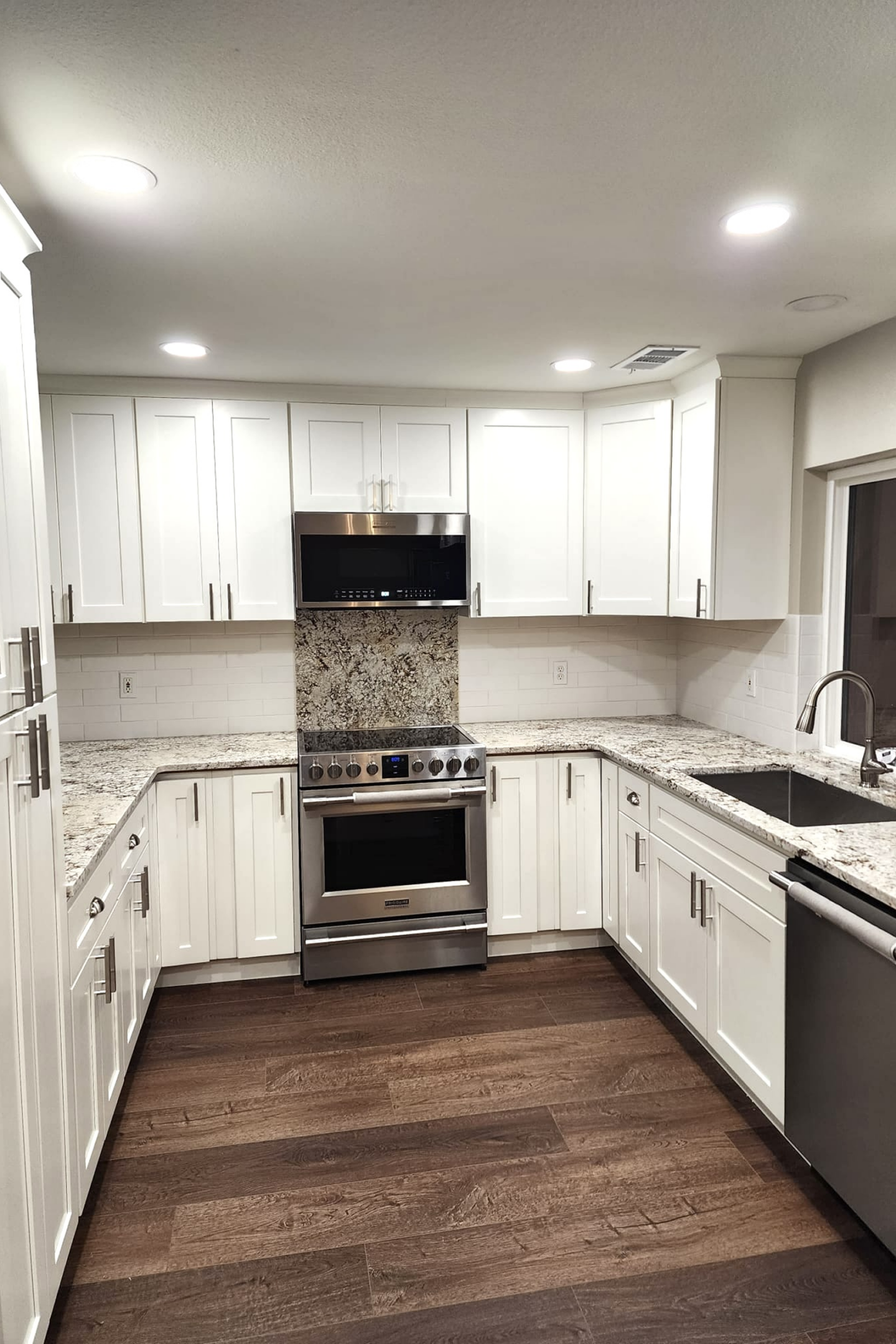 A kitchen with white cabinets and stainless steel appliances.