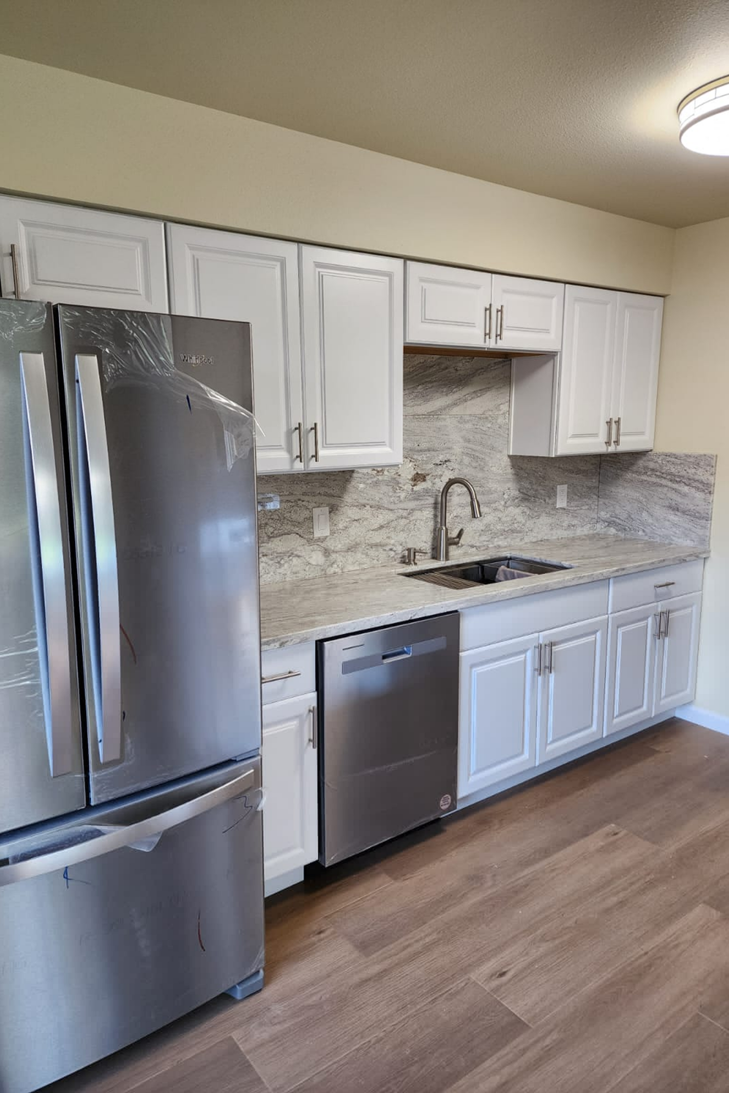 A kitchen with white cabinets and stainless steel appliances.