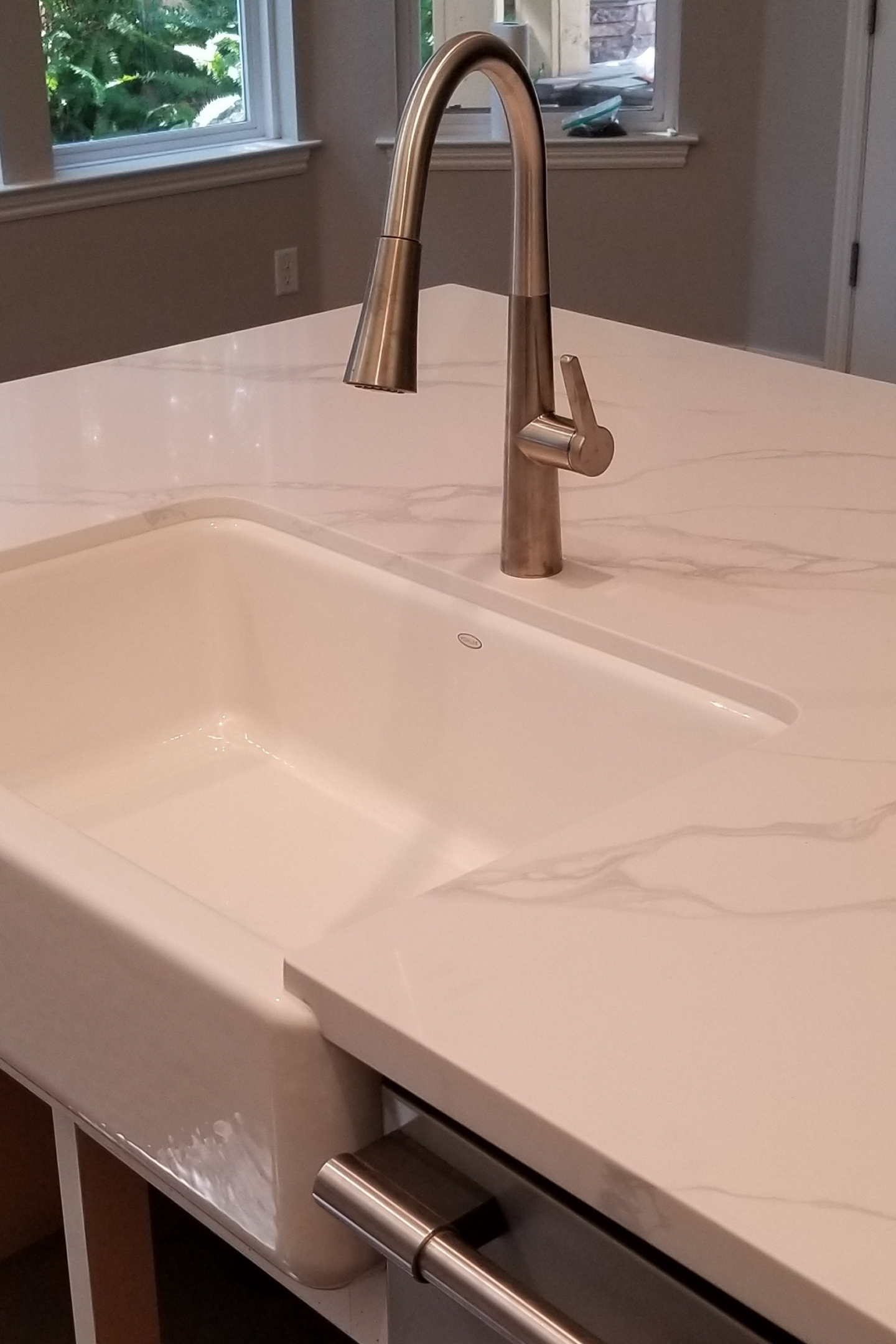 A white sink sitting under a faucet in the middle of a room.