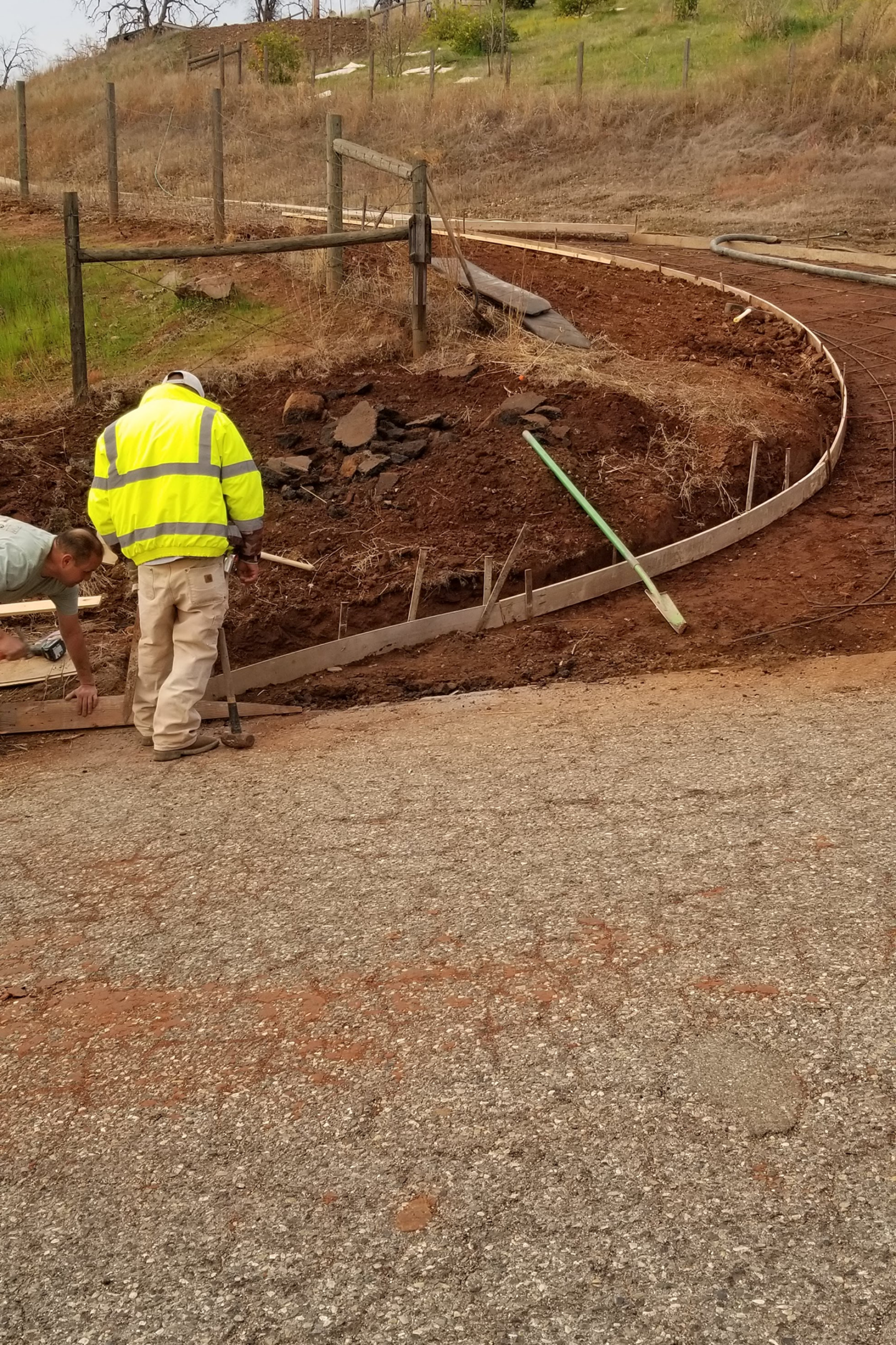 A man in yellow jacket standing next to dirt.