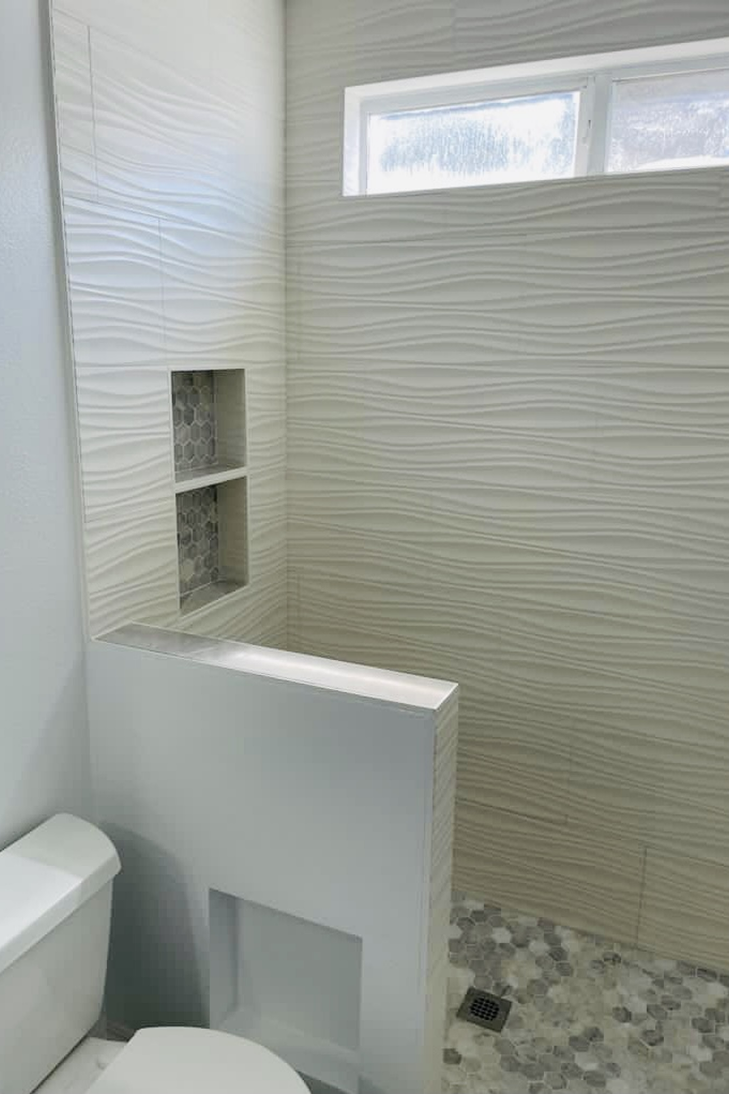 A bathroom with white walls and a toilet.