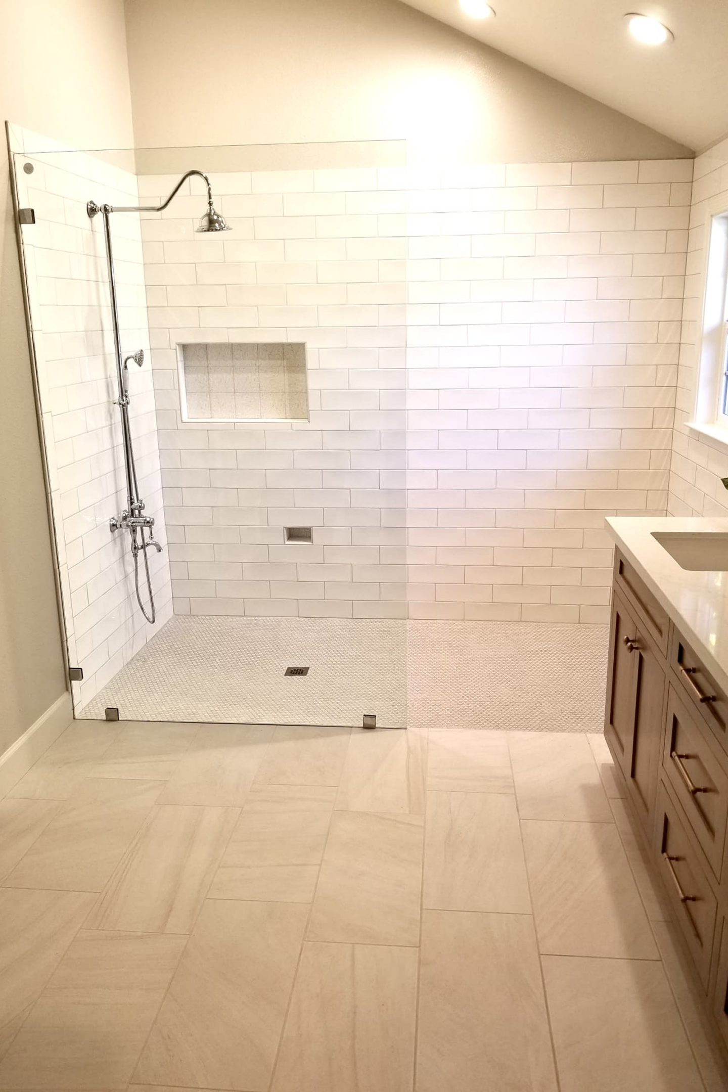 A bathroom with a shower and tiled floor.