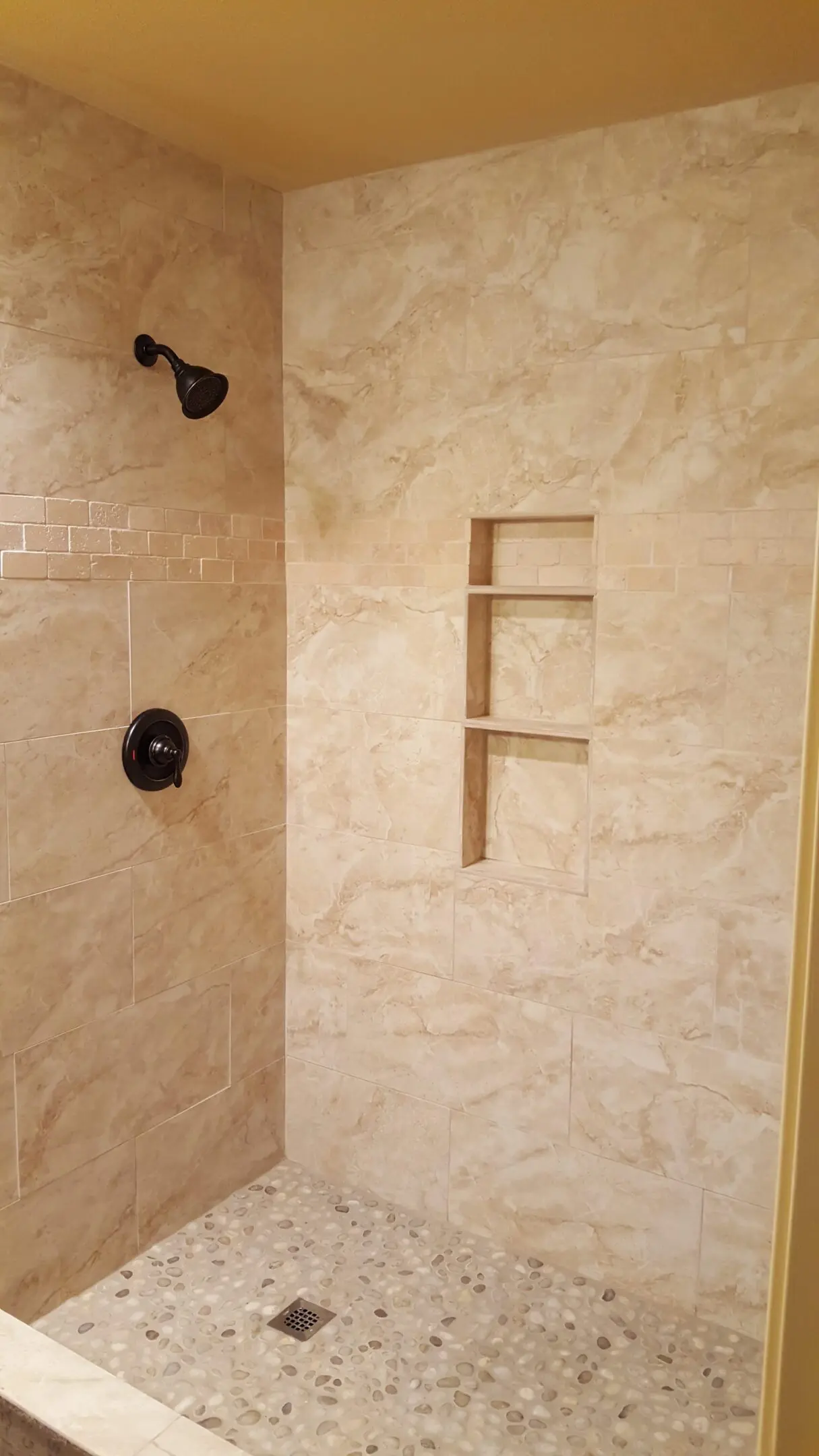 A bathroom with a shower and tiled walls.