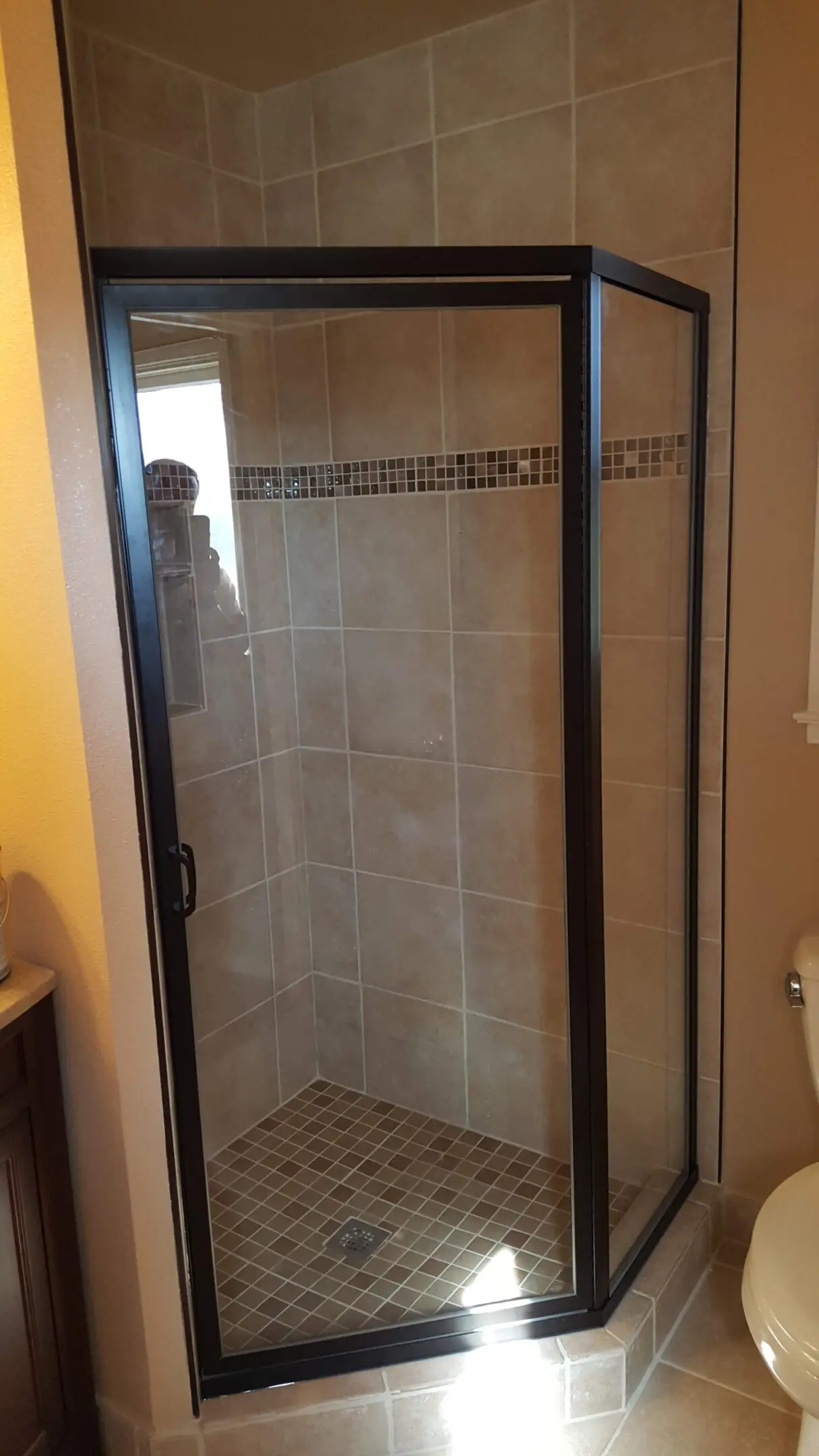 A bathroom with a shower and tiled walls.
